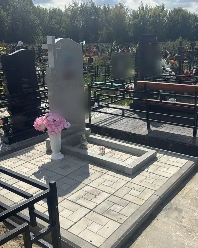 Участок из светлого гранита с плиткой, цветником и сквозным крестом