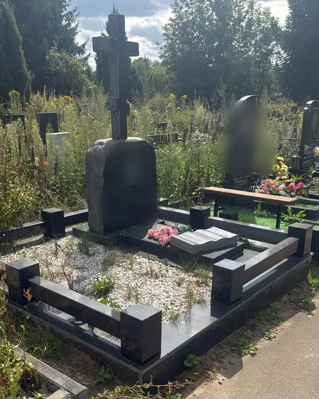 Гранитный крест и памятник-валун на участке с белой крошкой